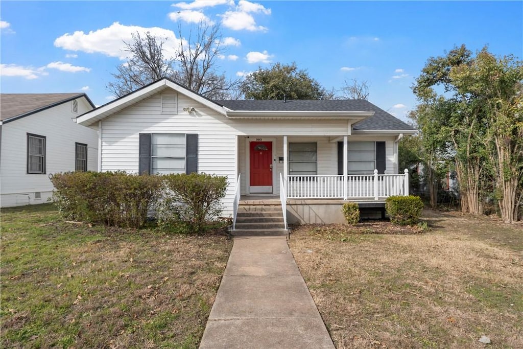 view of front of property with covered porch and a front yard