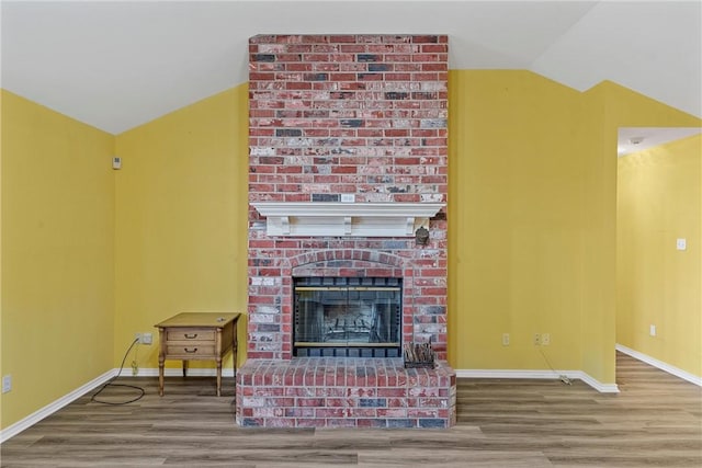 living room with wood-type flooring, lofted ceiling, and a fireplace