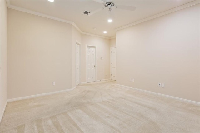 spare room featuring light carpet, ceiling fan, and crown molding