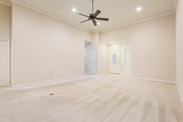 empty room featuring ceiling fan, light colored carpet, and ornamental molding