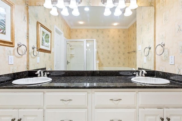 bathroom featuring vanity, a shower with shower door, and crown molding