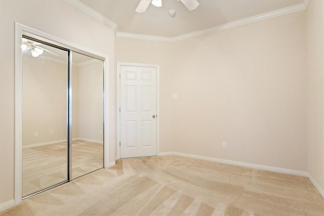 unfurnished bedroom with carpet floors, a closet, ceiling fan, and crown molding