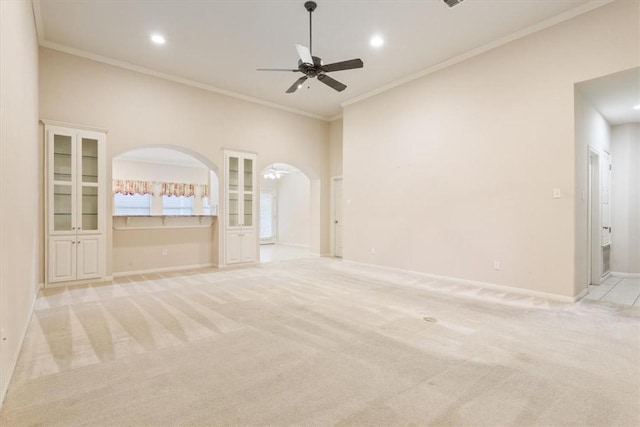 unfurnished living room with light colored carpet, ceiling fan, and ornamental molding