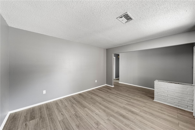 empty room featuring light hardwood / wood-style flooring and a textured ceiling