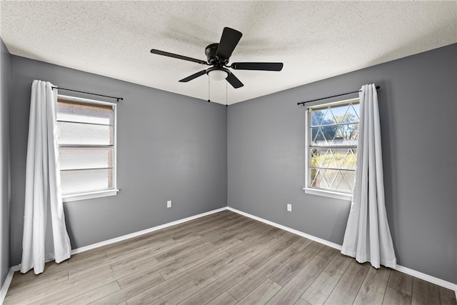 unfurnished room featuring light wood-type flooring, ceiling fan, and a textured ceiling