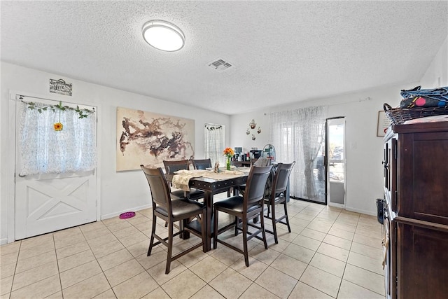 tiled dining area with a textured ceiling