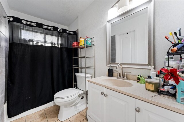 bathroom with curtained shower, tile patterned floors, a textured ceiling, toilet, and vanity