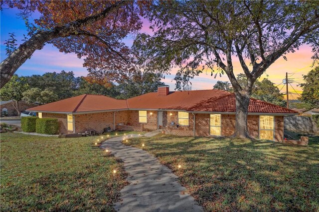 ranch-style home featuring a lawn