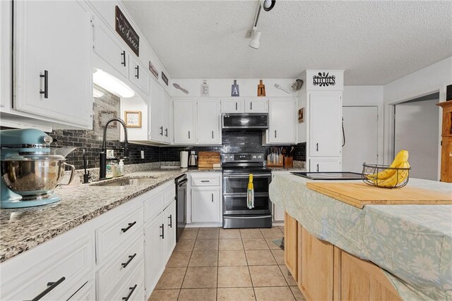 kitchen featuring backsplash, a textured ceiling, stainless steel appliances, sink, and white cabinetry