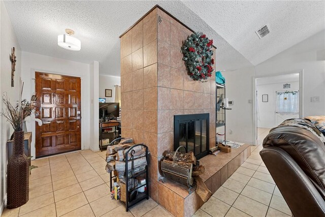 tiled living room with vaulted ceiling, a tiled fireplace, a textured ceiling, and tile walls