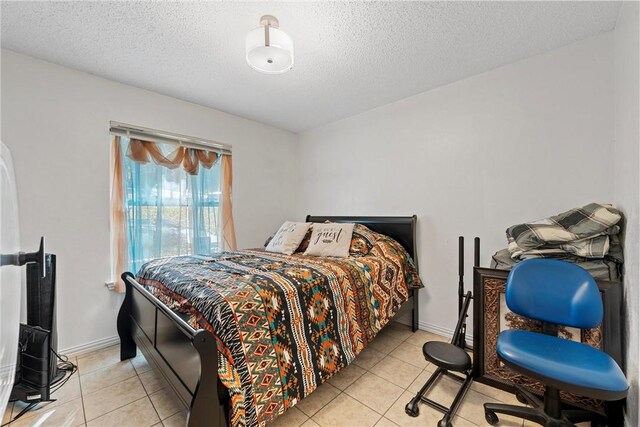 bedroom with light tile patterned flooring and a textured ceiling