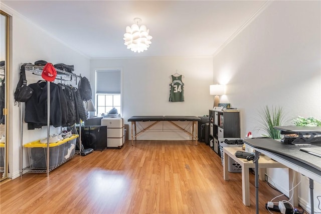 misc room with an inviting chandelier, ornamental molding, and wood finished floors