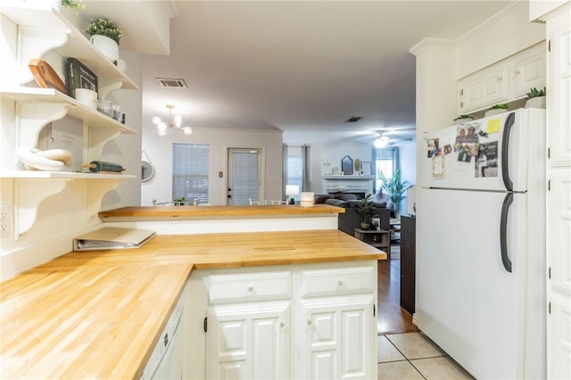 kitchen with ceiling fan with notable chandelier, a peninsula, white appliances, butcher block counters, and visible vents