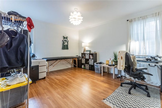 home office featuring ornamental molding, an inviting chandelier, and wood finished floors