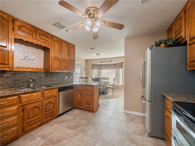 kitchen featuring sink, backsplash, stainless steel appliances, light tile patterned flooring, and kitchen peninsula