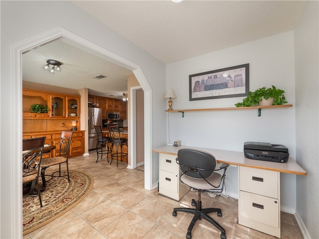 office area with light tile patterned flooring and a textured ceiling