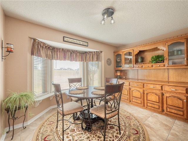 tiled dining area featuring a textured ceiling