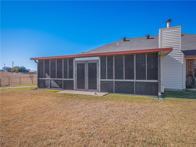 back of house with a sunroom and a yard