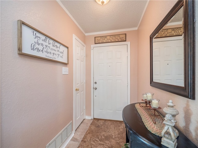 entryway with ornamental molding and a textured ceiling