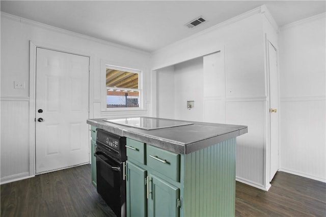 kitchen featuring dark hardwood / wood-style flooring, green cabinets, black appliances, and a kitchen island