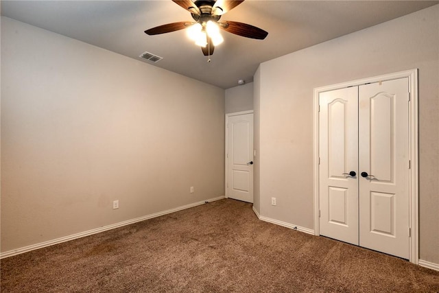 unfurnished bedroom featuring ceiling fan, dark carpet, and a closet