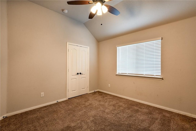 carpeted spare room featuring ceiling fan and vaulted ceiling