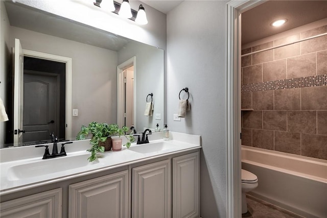 full bathroom featuring toilet, vanity, and tiled shower / bath combo