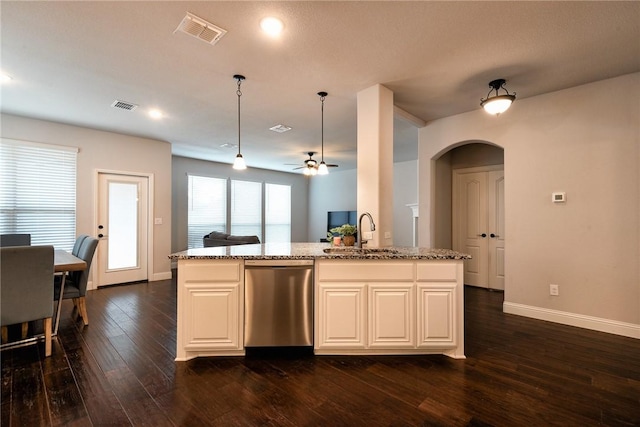 kitchen featuring dishwasher, a center island with sink, sink, hanging light fixtures, and light stone countertops