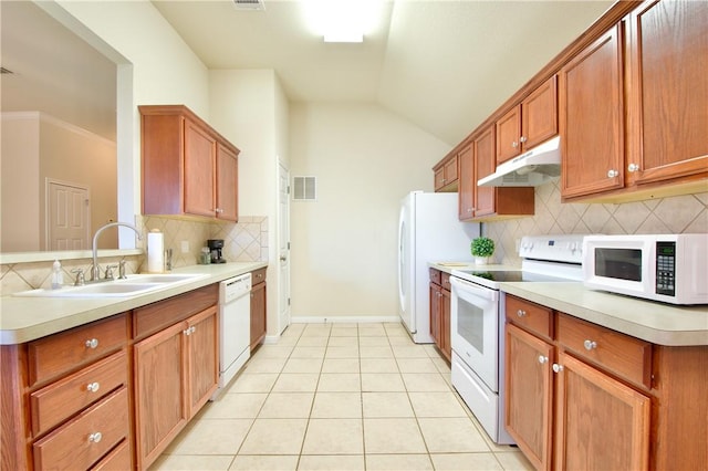 kitchen featuring white appliances, sink, vaulted ceiling, tasteful backsplash, and light tile patterned flooring