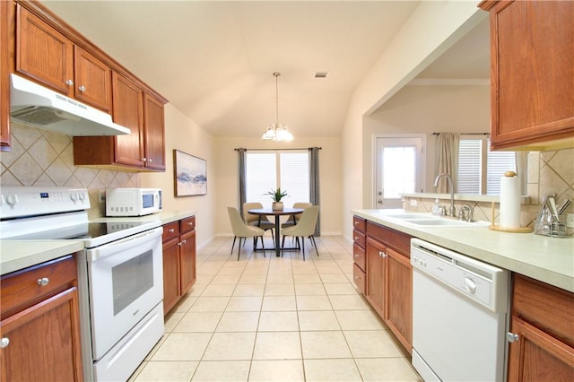 kitchen featuring sink, a notable chandelier, pendant lighting, white appliances, and decorative backsplash