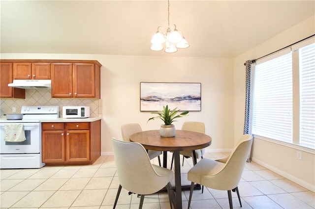 kitchen featuring tasteful backsplash, a chandelier, decorative light fixtures, white appliances, and light tile patterned floors