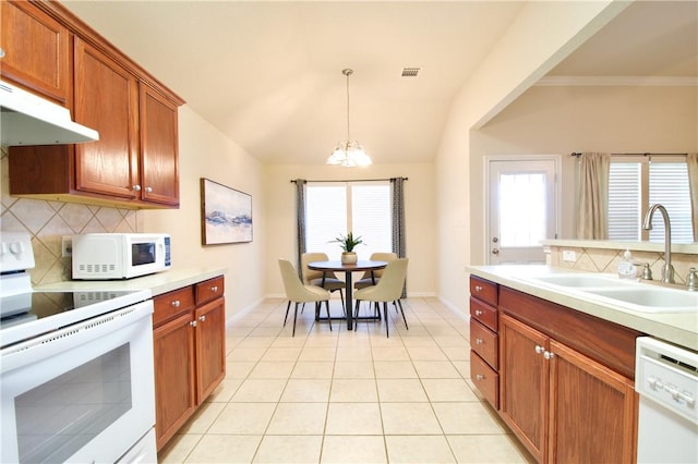 kitchen with backsplash, a wealth of natural light, white appliances, sink, and pendant lighting