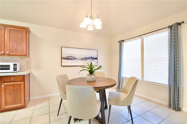 tiled dining area featuring an inviting chandelier