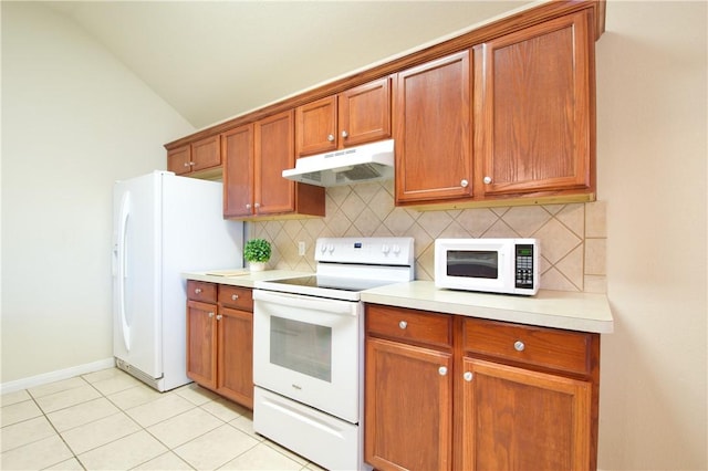 kitchen featuring decorative backsplash, lofted ceiling, light tile patterned flooring, and white appliances