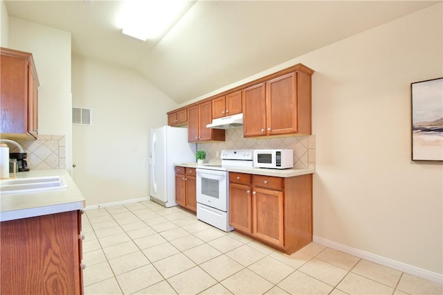 kitchen with vaulted ceiling, backsplash, sink, and white appliances