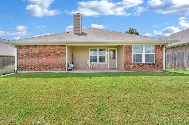 back of house with a patio area and a yard