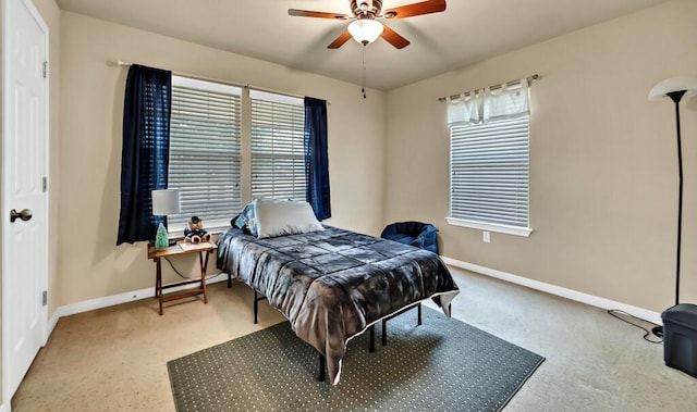 carpeted bedroom with multiple windows and ceiling fan