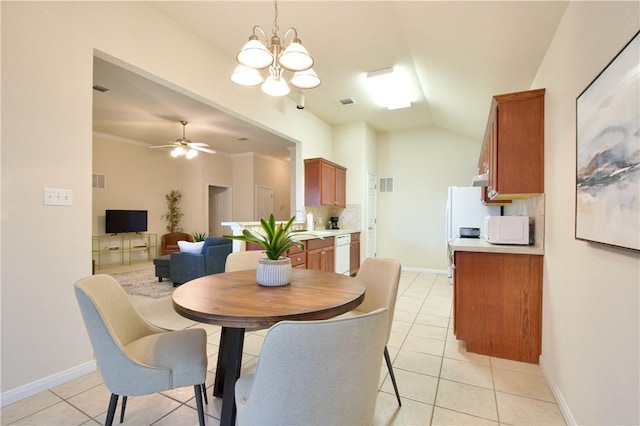 tiled dining space featuring lofted ceiling, ceiling fan with notable chandelier, and ornamental molding