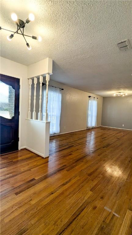 foyer with wood-type flooring, visible vents, plenty of natural light, and a textured ceiling