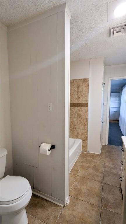 bathroom with a washtub, a shower, a textured ceiling, and toilet