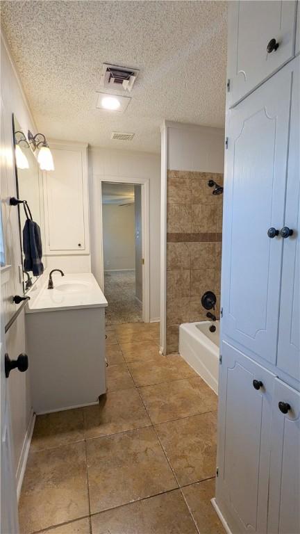 bathroom with visible vents, shower / washtub combination, a textured ceiling, and vanity