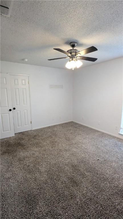 unfurnished room with baseboards, visible vents, ceiling fan, a textured ceiling, and carpet flooring