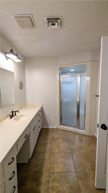 bathroom featuring visible vents, a stall shower, vanity, a textured ceiling, and tile patterned flooring