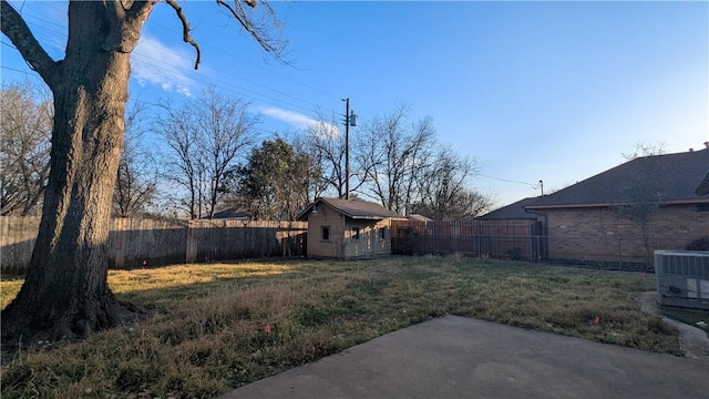 view of yard with central AC, a patio, an outdoor structure, and a fenced backyard