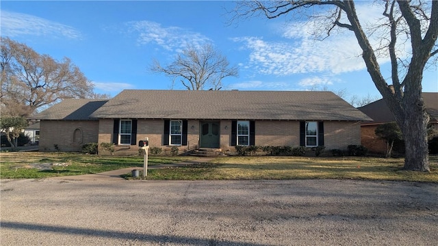 ranch-style home featuring brick siding and a front yard