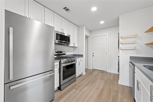 kitchen featuring white cabinetry, stainless steel appliances, and light wood-type flooring