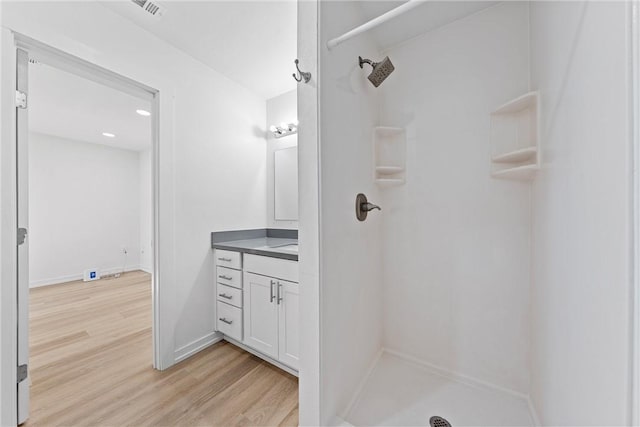 bathroom featuring a shower, vanity, and hardwood / wood-style flooring