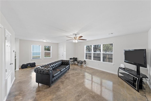 living room featuring concrete flooring and a wealth of natural light