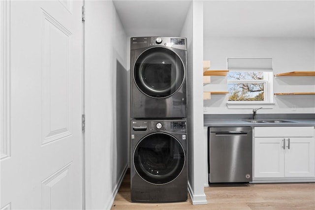 laundry room with light wood-type flooring, stacked washer / dryer, and sink