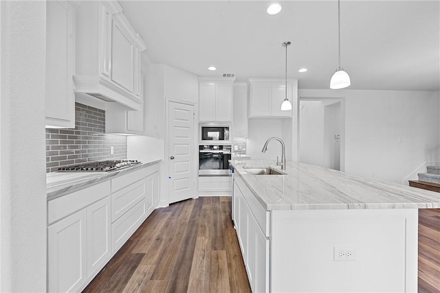 kitchen with a center island with sink, sink, white cabinetry, and stainless steel appliances